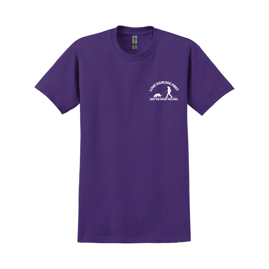 Lila T-Shirt mit kleinem weißen Frontprint eines Mantrailing-Teams (Hundeführer mit suchendem Hund) und dem Text „Love your dog first and the sport second“, vor weißem Hintergrund.