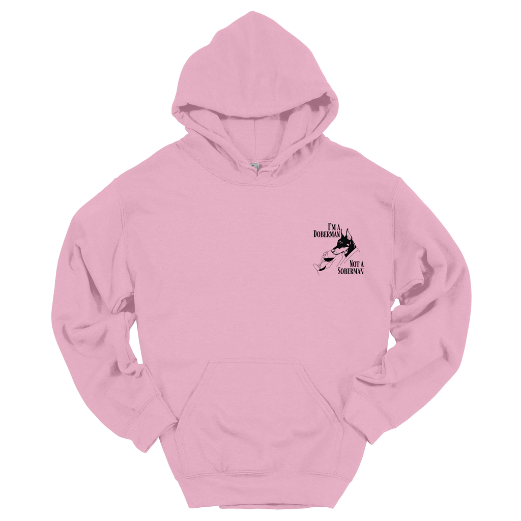 Rosa Hoodie mit kleinem schwarzen Frontprint „I’m a Doberman, Not a Soberman“ und Dobermann-Illustration; Produktfoto vor weißem Hintergrund.