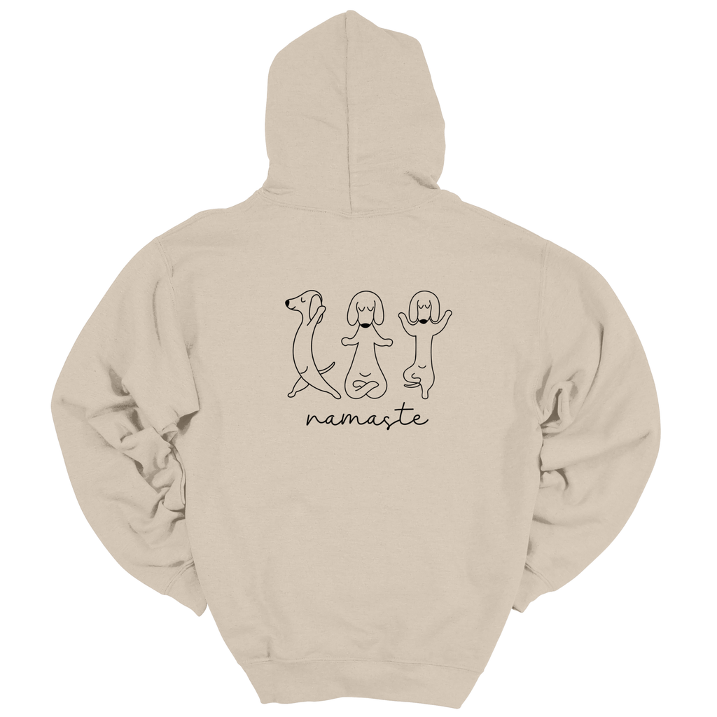 Beiger Hoodie mit großem Rückenprint: drei minimalistisch gezeichnete Hunde in Yoga-Posen und der Schriftzug „namaste“ darunter; Produktfoto vor weißem Hintergrund.