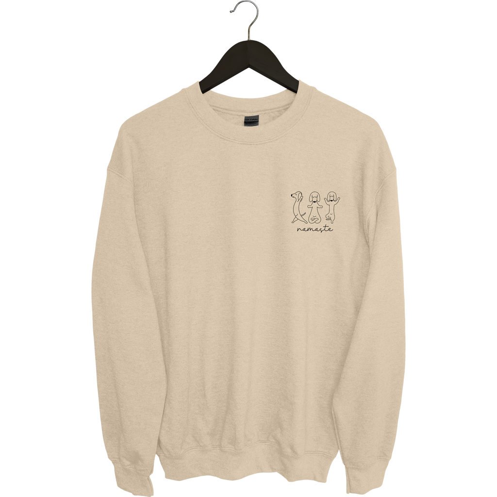 Beiger Sweater mit kleiner Frontgrafik von drei Hunden in Yoga-Posen und dem Schriftzug „Namaste“