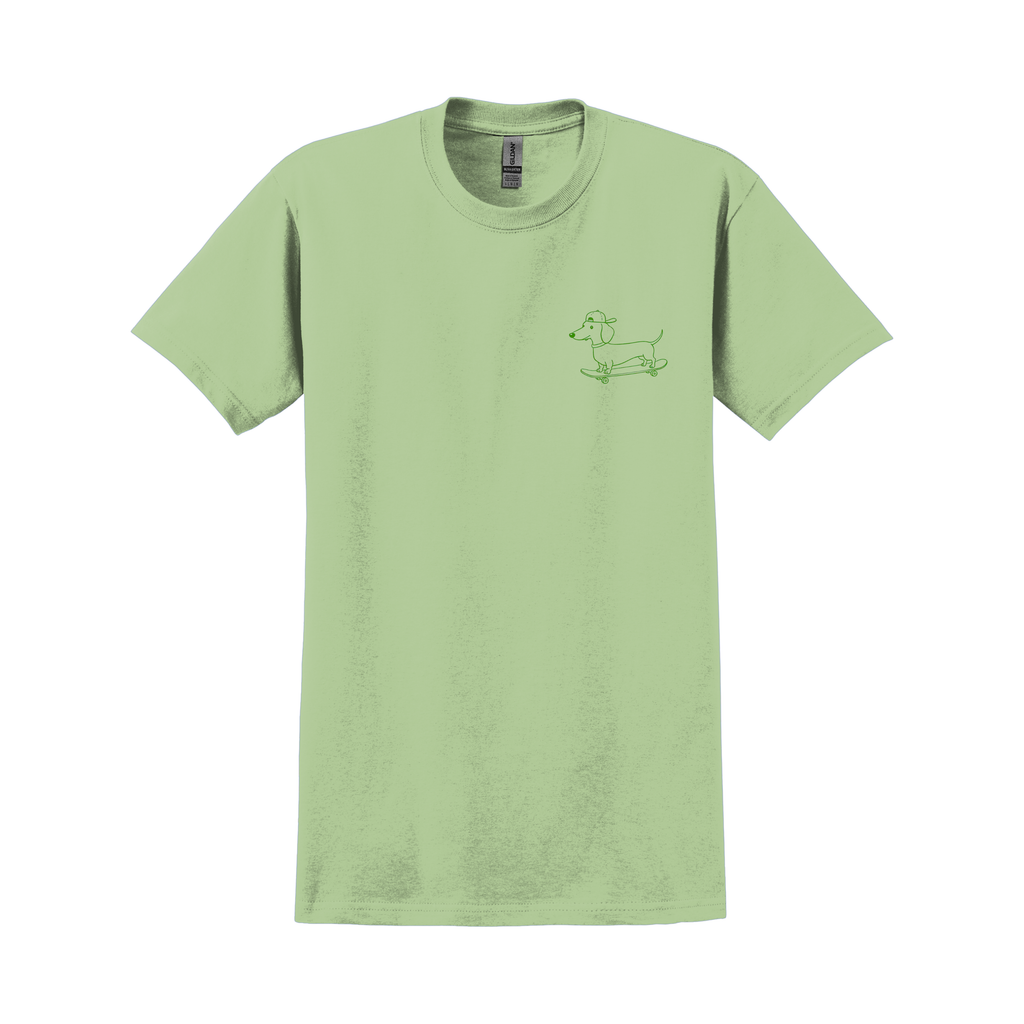 Grünes T-Shirt mit kleinem Frontprint eines Dackels auf einem Skateboard in grüner Linienzeichnung; Produktfoto vor weißem Hintergrund.